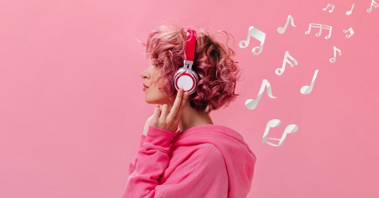 Portrait of curly pink haired woman in massive white headphones